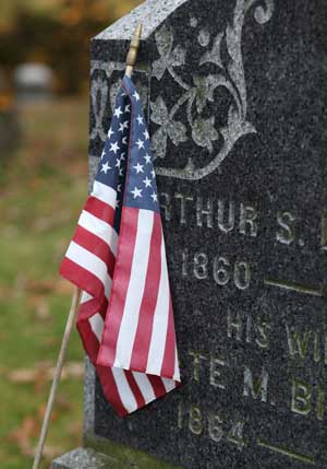 An American flag decorates a veteran’s  grave at Bellevue Cemetery. (Photo by Lisa Aciukewicz)