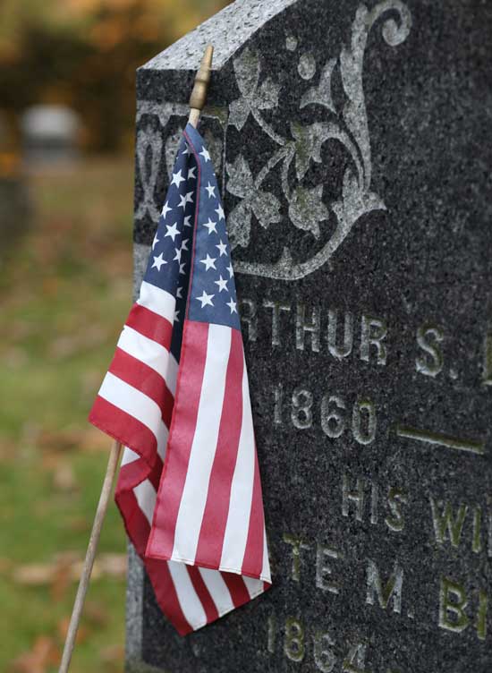 An American flag decorates a veteran's grave for Veterans Day at Bellevue Cemetery.