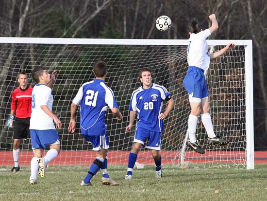 From left: Goalkeeper Will Nocka and Brian Mandozzi watch as Brian McCullough (in air)  tries to block the ball against two Whittinsville Christian opponents. Bromfield won the game 7-2 to move on to the district semifinals on Nov. 11. (Photo by Lisa Aciukewicz)
