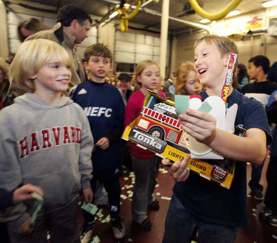 From left, Jack Sennott, Kyle Schoenberg, Julia Hawes, and Shea Oldham watch as Colin Murphy walks off with his spoils during the annual Firefighters Turkey Raffle.