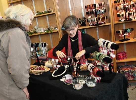 Kate Ford shows her jewelry to a customer at the Historical Society's holiday arts festival and sale at the old library on Dec. 4.