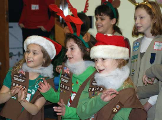 Girl Scouts sing Christmas carols for Harvard’s senior citizens as part of the Girl Scouts Holiday Tea held in at Holy Trinity Parish on Dec. 16. (Photo by Sue Fitterman)