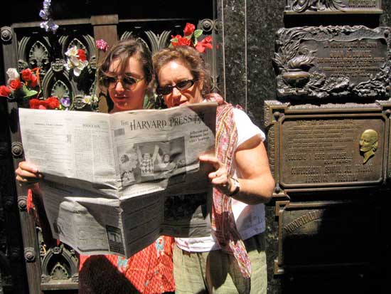 Lydia Cardenas (left) and her mother Laurie Lingham read the Press in front of the Duarte family tomb, where Eva Peron is buried, in the La Recoleta Cemetery in Buenos Aires.