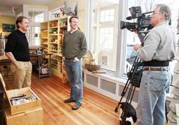 From left: General Store proprietor Adam Horowitz jokes with anchor Anthony Everett of the WCVB television show Chronicle, as cameraman Carl Viera gets some footage for an upcoming segment on Harvard. (Photo by Lisa Aciukewicz)