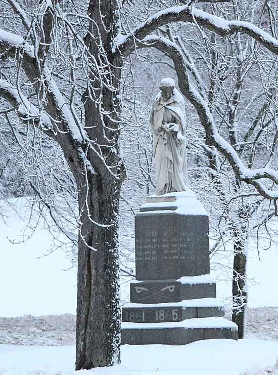 Fresh snow on elm branches frames the Civil War memorial on the Common.