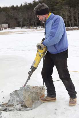 Tom Cotton breaks up a rock in Bare Hill Pond in an effort to clear the pond of boat-damaging rocks that lie just below the surface. (Photo by Lisa Aciukewicz)