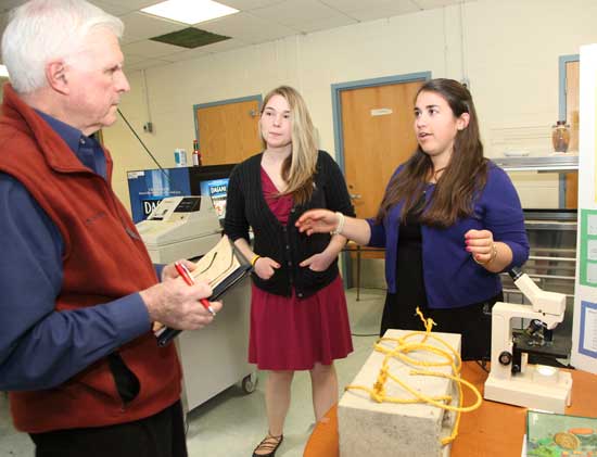 Judge George Symula talks with 12th-graders Emily Metzger (center) and Andrea D'Eramo about their project, "Diatoms: a Study of Water Health."