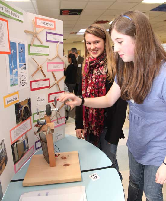 Nikki Margaretos (right) and Katya Schwiegershausen investigate aspects of wind turbines and their generators at the Bromfield Science Fair on Feb. 5.