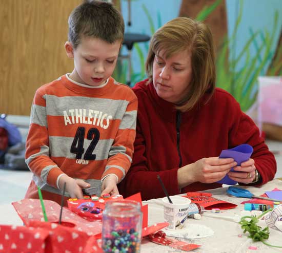 Kindergartener Cameron Milliken and his mother, Nancy, work on their projects.