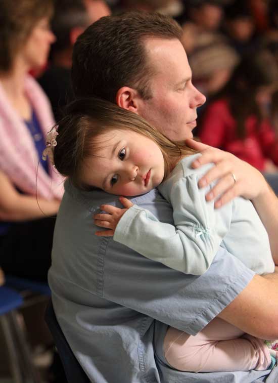 Following his performance, David Fitzgibbons of The Rafters watches the show while his daughter, Tilly, enjoys the comfort of his shoulder.