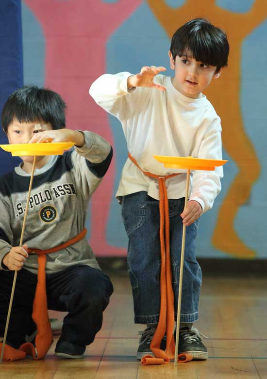 Jelin Zhong and Cameron Krug spin plates at a performance of circus tricks. The March 8 show marked the end of a two-week Circus Smirkus residency at the elementary school.  
