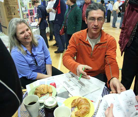 Kathy Waugh and her husband Francis Begue relax at a café table and stamp passports between eating croissants and reading Le Monde. 