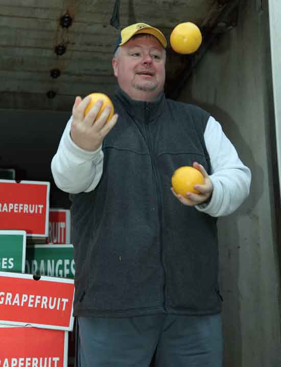 Lions Club member Gary Clements juggles grapefruit, entertaining customers at the Lions' annual fruit sale at the transfer station.