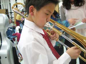 Kee Hwang Lee warms up on his trombone. (Photo by student photographer) Kee Hwang Lee warms up on his trombone. (Photo by student photographer)