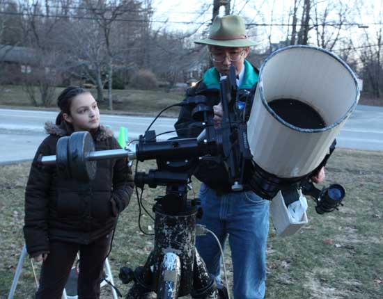 Samantha Merrow watches as Al Takeda of the Amateur Telescope Makes of Boston adjusts his telescope.