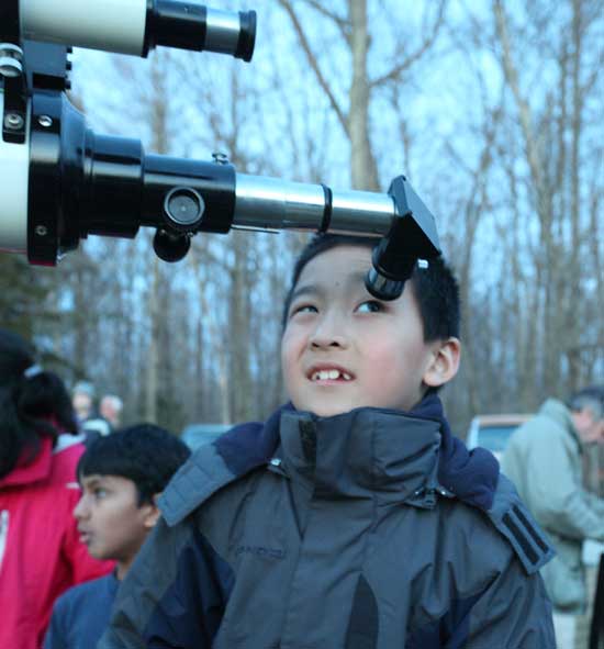 Kevin Yu checks out a telescope pointed at a more earthly target—­the weather vane atop the Unitarian Church in the center of town.