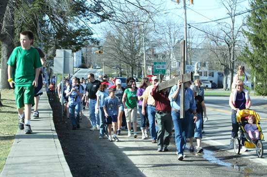 Members of Holy Trinity Parish walk down Mass Ave. carrying a cross from their Harvard site to their Bolton site on Good Friday, April 2.