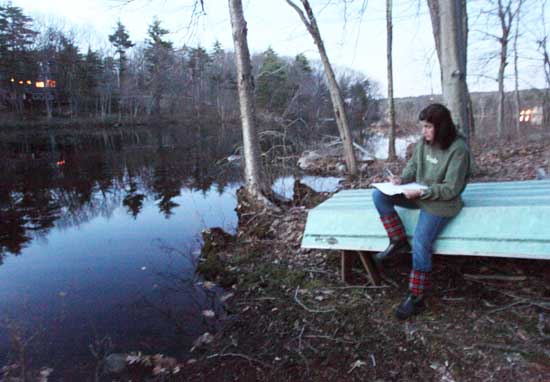 Elizabeth Swain listens for frogs as she sits next to Bare Hill Pond during a frog count on April 5.