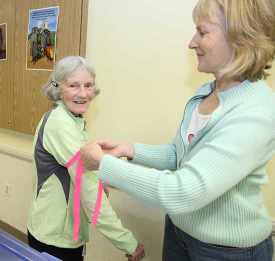 Jeanie Colony (right) ties an armband on Ruthie Broughton. Ruthie has walked more than 655 miles during the past 32 years of participating in the Good Friday Walk.