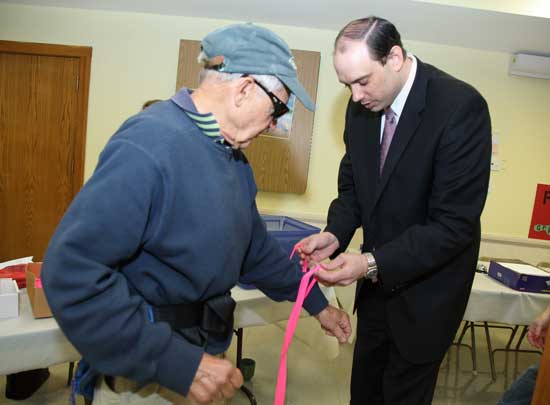State Senator Jamie Eldridge ties a ribbon around Brint Ferguson's wrist as he prepares to start the walk.