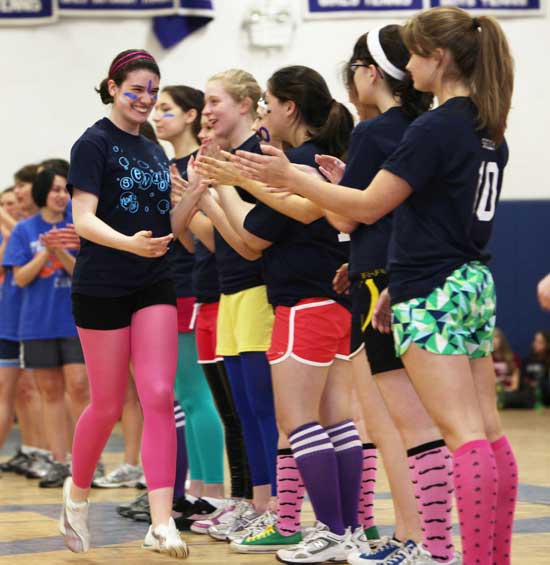 Dominique Ledoux tags the hands of her teammates as the teams are introduced.