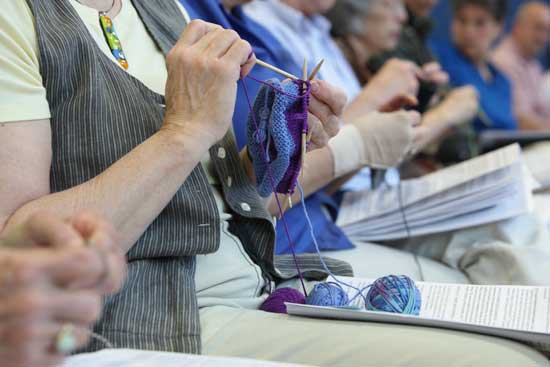 Town Meeting knitters make good use of the time, pausing only to raise their hands to vote.
