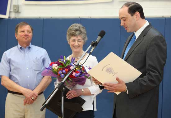 Board of Selectmen Chairman Ron Ricci (left)  listens as Lucy Wallace, just named Citizen of Note for 2009, is further lauded by State Senator Jamie Eldridge.