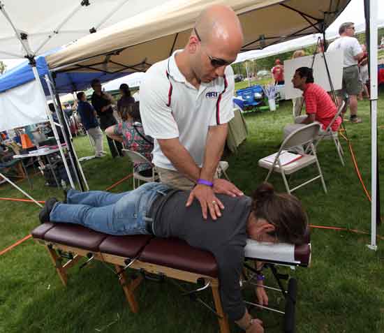Dr. Chad Messina of Messina Family Chiropractic in Marlborough gives Hellie Swartwood a complimentary chiropractic assessment at the Wellness Fair held on the lawn of the library on May 2.