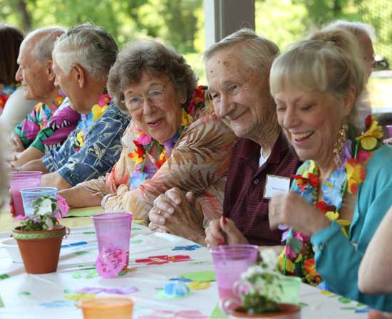 From left: John Zimmer, Ken Van Wormer, Natalie Ohlin, Hans Ohlin, and Bonnie Morehouse swap stories before lunch at the Council on Aging luau at the Hildreth House on May 21.