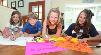 Sarah vandeVaart, Patrick Flanagan, Sadie Flanagan, and Elly vandeVaart make signs for the lemonade sale to be held Sunday, June 6, on the Common to raise money to cure cancer. (Photo by Lisa Aciukewicz)