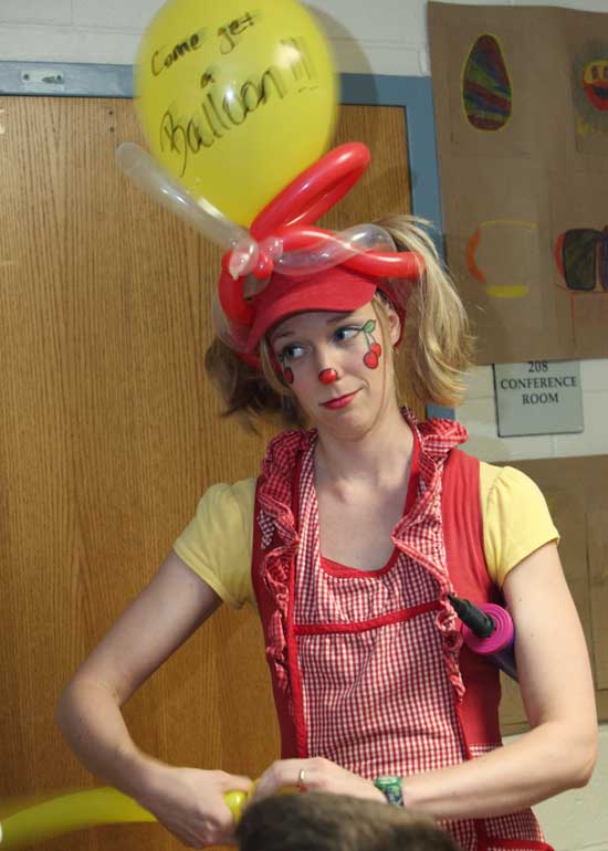Cherry the Clown entertains the crowd by making a balloon animal.