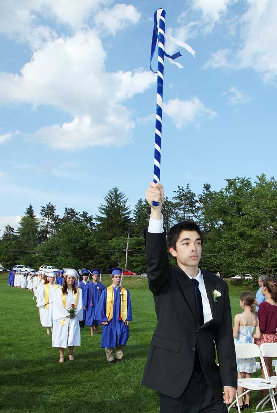 Junior Andrew Hong leads the graduation class toward the stage as the class marshal.