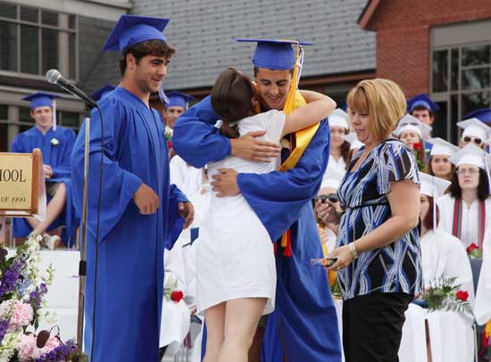 Jen Fraser hugs Ben Landry (center) after the class of 2010 thanked its advisors for  their help over the years. From left are Jake Basile, Spanish teacher Jen Fraser, Ben Landry, and science teacher Patricia Nilan