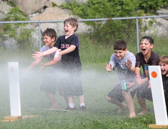 From left, Connor O’Shea, Tommy Nigzus, Zac Sclar, Michael Thornton, and Charlie Frost get sprayed by a toned-down firehose at the PTO Fun Fair on June 14.