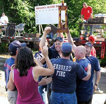 Harvard firefighter Greg Harrod (center) holds up the winning trophy as his teammates celebrate with him. (Courtesy photo) Harvard firefighter Greg Harrod (center) holds up the winning trophy as his teammates celebrate with him. (Courtesy photo)