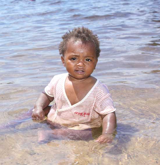 Baby Halo, the Morin family’s foster child, plays in the shallow water at the town beach.