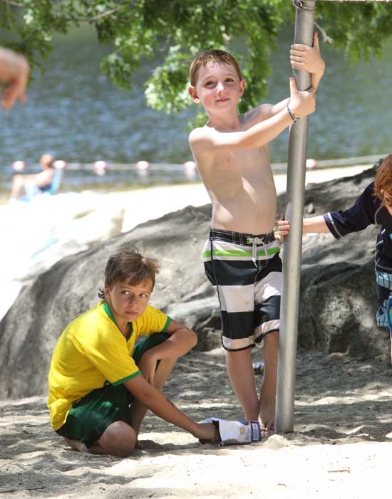 Nico Agosta (left) and Connor Gothorpe watch older youths play a game of “nuke ‘em” at the volley court.