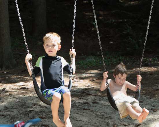William Gothorpe and Jason Morin play on the swings at the town beach.