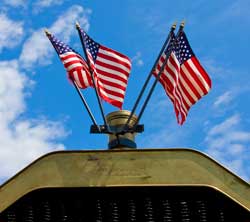 Flags decorate the hood of one of the vintage cars. (Photo by Tyler Papazian)
