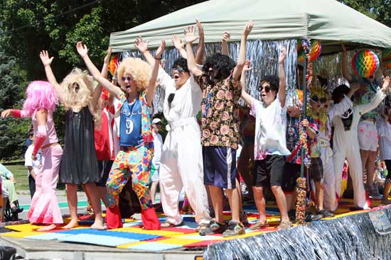 An enthusiastic bunch of children sings and acts out the Village People’s 1979 hit “YMCA.” This TP Hazel Sotheby’s float took first place with its ’70s disco theme.