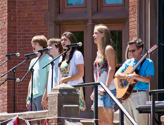 The Bromfield a capella group, (from left) Phil Stapleton, Tyler Borton, Molly O’Rourke-Friel, and Katherine Friedrich, sings the “Star Spangled Banner” as Steve Peisch listens. (Photo by Tyler Papazian)