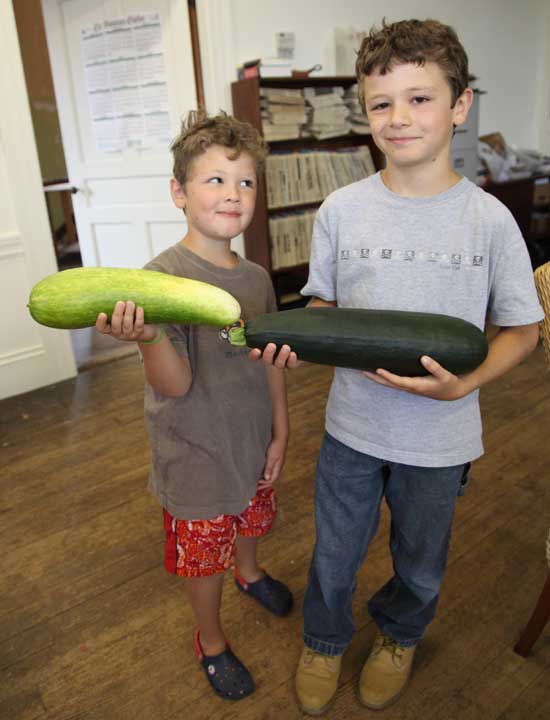 Ben Carbonnel, left, with a 13-inch cucumber, and Charlie Carbonell with a zucchini that measured about 16 ½ inches.