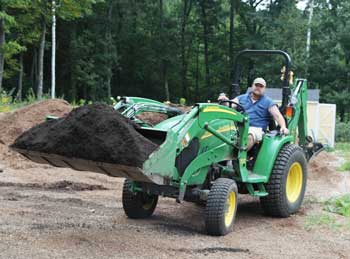 Jim Croyle Jr. carries a load of compost with his tractor. (Photo by Lisa Aciukewicz)