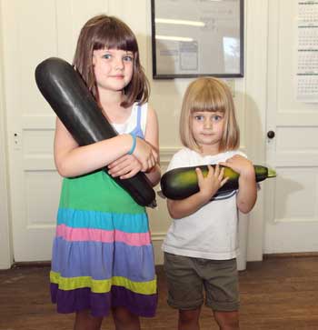 Erin (left) and Marissa Flynn crade their winning zucchini. Erin (left) and Marissa Flynn crade their winning zucchini.