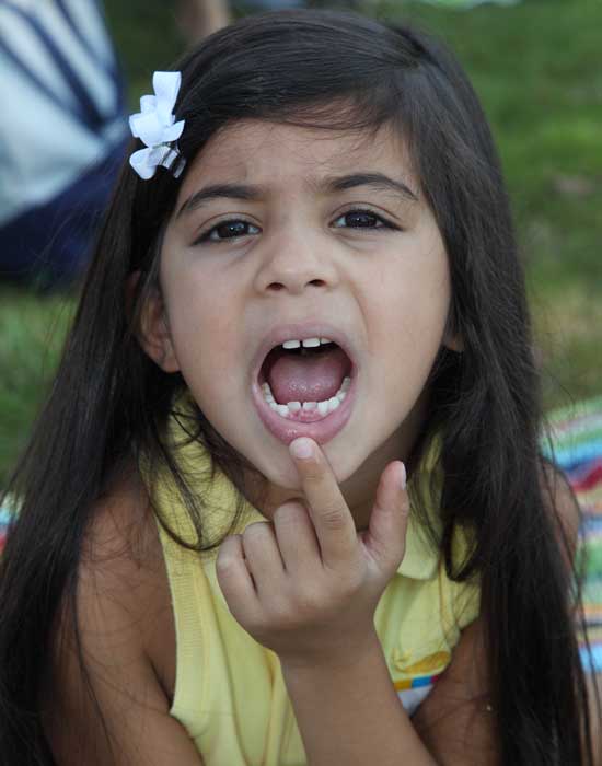 Incoming kindergartener Asha Khurana shows off her incoming teeth.