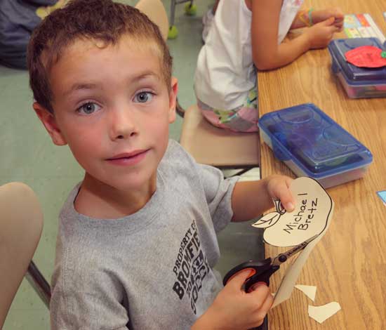 Michael Bretz cuts out his name tag on his first day in Mrs. Chapman’s first-grade class