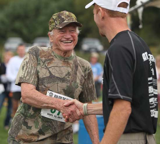 Ken Nygren (left) is congratulated by Harvard Conservation Trust Race for the Hills organizer Ted MacMahon at McCurdy Track on Sept. 12. Nygren finished first in the 70+ age bracket.
