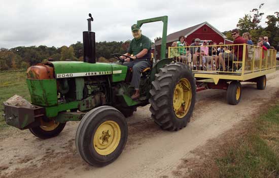Warren Harrod pulls a haywagon full of pumpkin pickers out to the fields at Westward Orchards on Sept. 27.