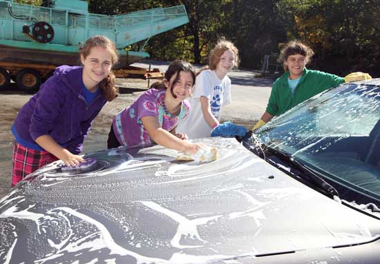 From left, Lucy Opalka, Carlisle Ferguson, Eleanor Willard, and Suzy Opalka pause while washing a car during a Girl Scout fundraiser at the transfer station on October 2.