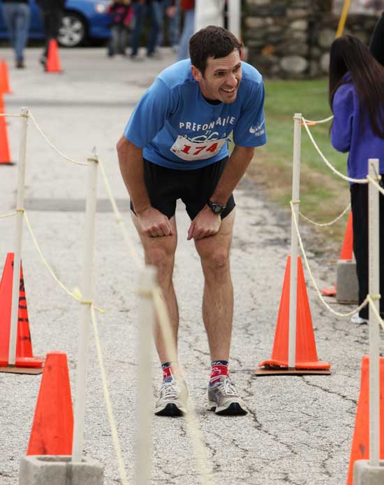 Roy Van Cleef pauses at the finish line to catch his breath after finishing second overall and first for Harvard males. 
